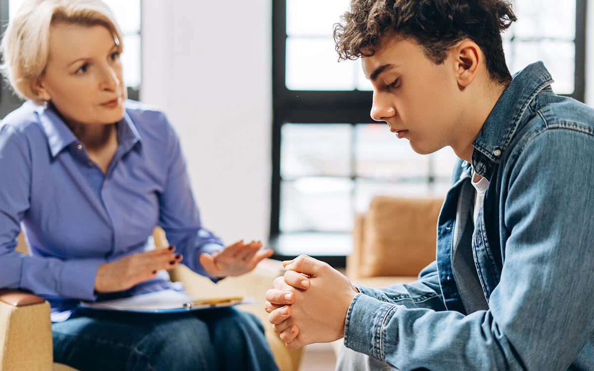 Teen speaking with a mental health professional during a one-on-one therapy session.